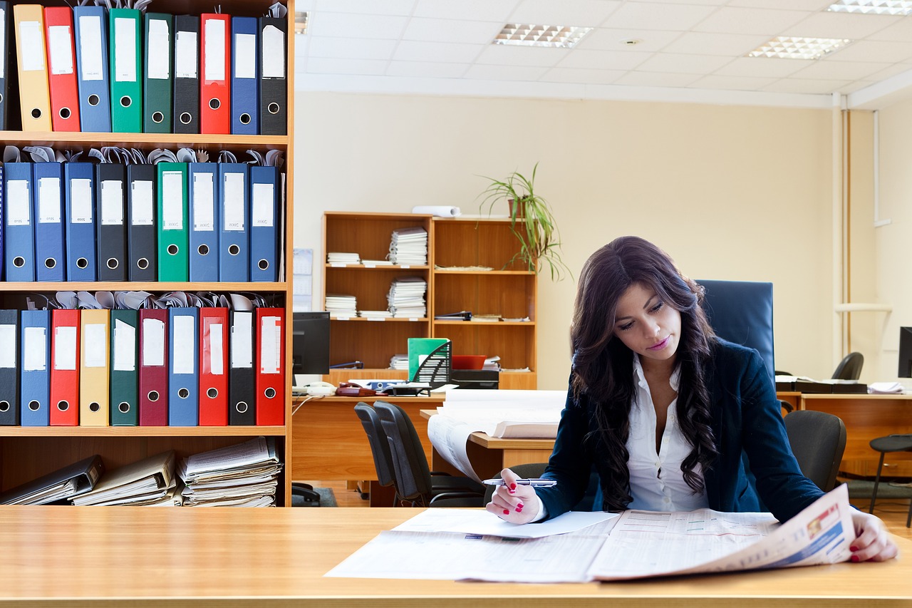 Red herring prospectus reading: an investor going through a thick printed offer document with a pen at an office desk