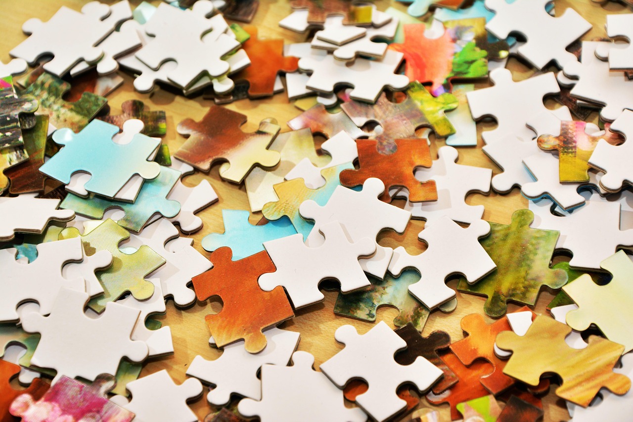 Minority interest in results: scattered jigsaw puzzle pieces, some white and some coloured, on a wooden table