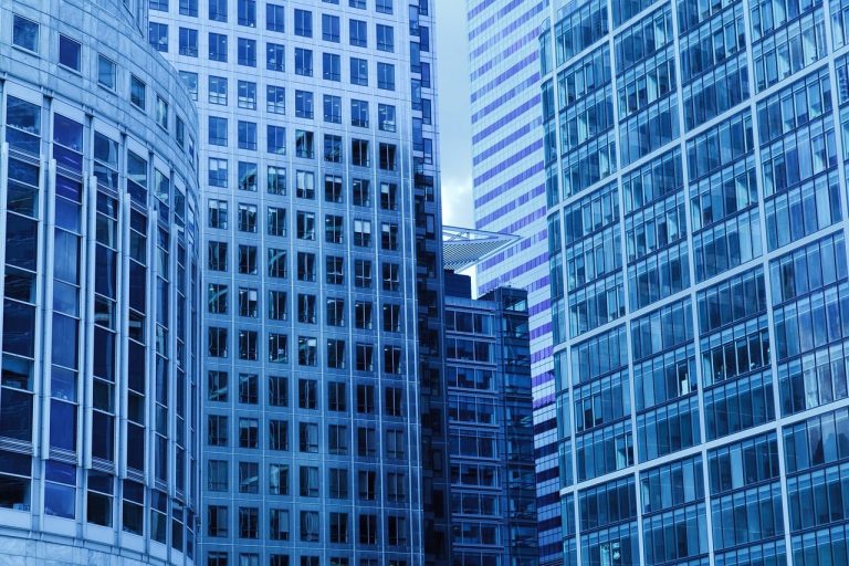 REIT investing in India concept: glass-fronted office towers of the kind listed REITs own and lease to tenants