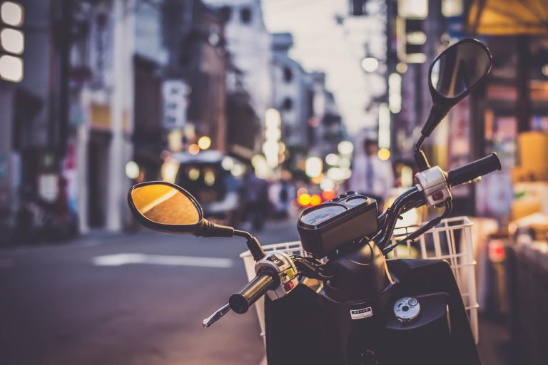 TVS Motor credit rating: a parked scooter on a busy city street at dusk