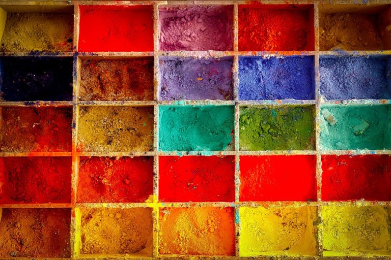 Sudarshan Chemical credit rating: trays of bright red, yellow, blue and green pigment powders