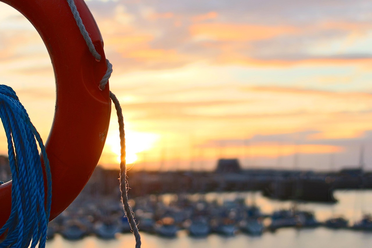 Interest coverage ratio: an orange life ring with blue rope hanging at a marina at sunset