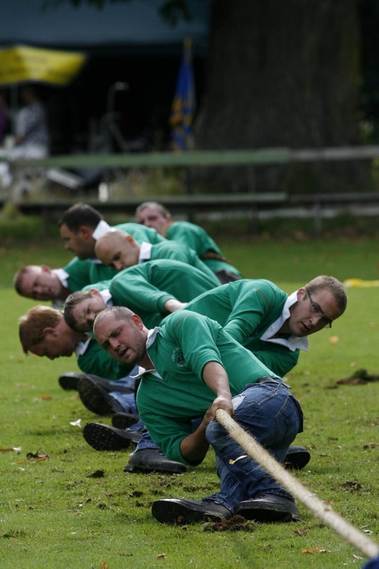 Force index indicator concept: a team in green shirts straining on a tug-of-war rope