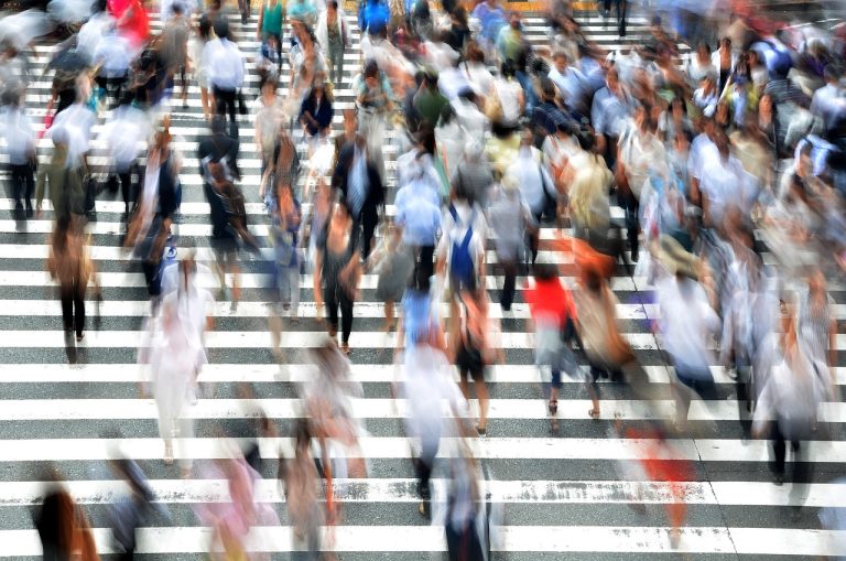 Advance decline line concept: crowd of pedestrians crossing a busy street in both directions