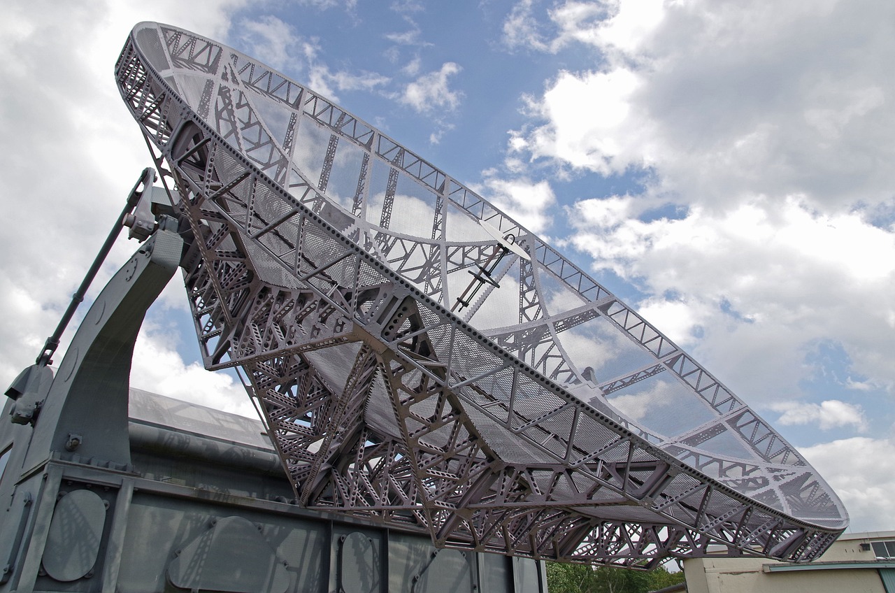 Apollo Micro Systems Q2 results: a large military radar dish against a cloudy sky