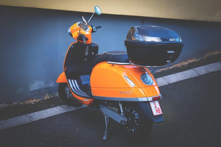 Ather Energy Q2 results: an orange electric scooter parked on a street kerb