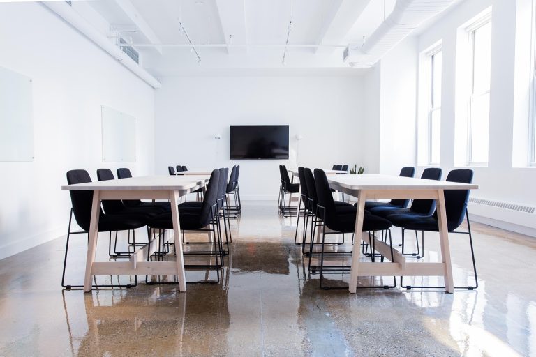 Auditor resignation concept: an empty company conference room with chairs around a white meeting table