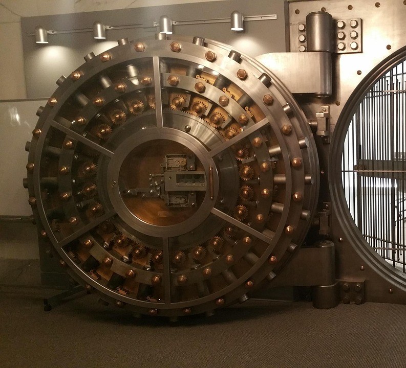 Banking and PSU fund concept: a heavy round steel bank vault door with brass bolts