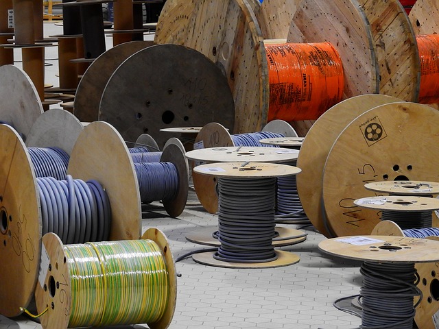 BLS Polymers IPO: wooden drums of insulated electric cable stacked on a warehouse floor