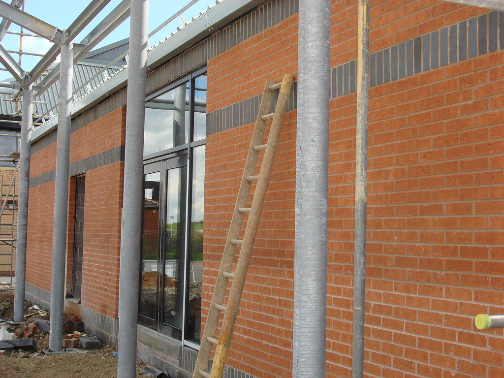 Bull put ladder options strategy: a wooden ladder leaning against a brick wall on a building site