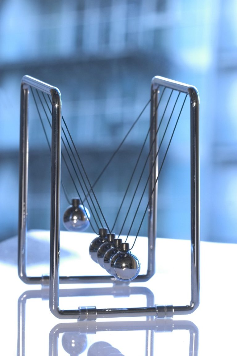 Chande momentum oscillator concept: a chrome Newton's cradle with one ball swinging out