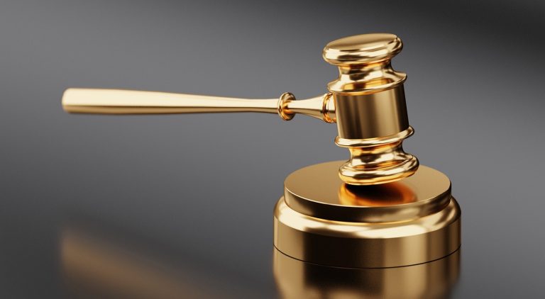 Contingent liabilities meaning concept: a gold judge's gavel resting on its block against a grey background