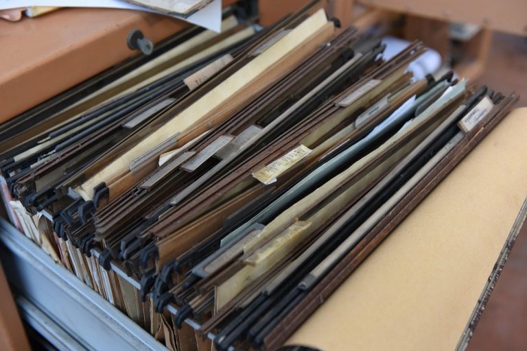 Convert physical shares to demat: an open drawer of old hanging file folders holding paper records