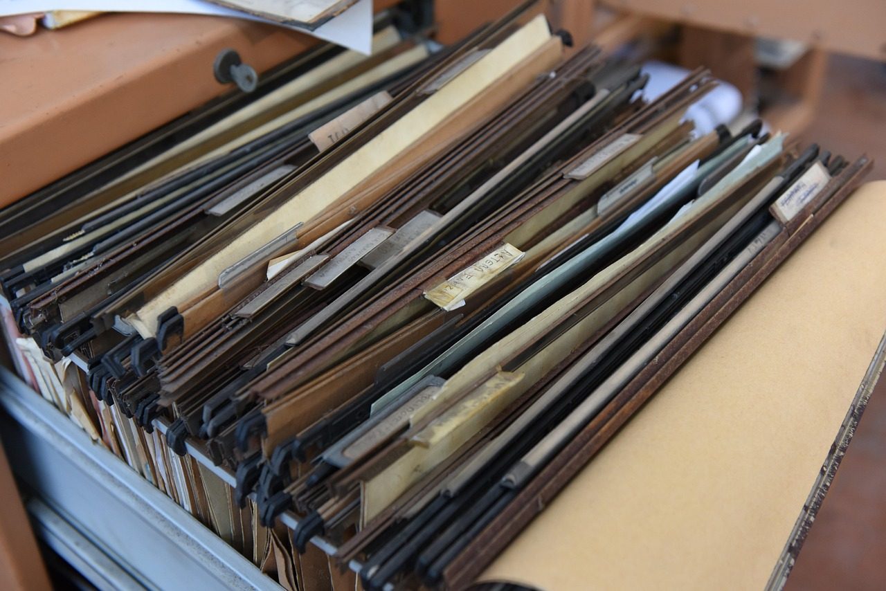 Convert physical shares to demat: an open drawer of old hanging file folders holding paper records