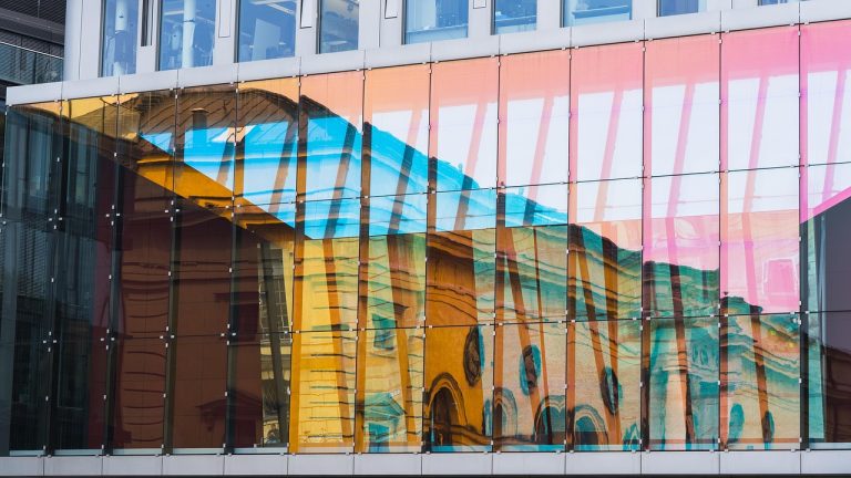 Corporate bond fund: glass facade of a modern office building with colourful reflections