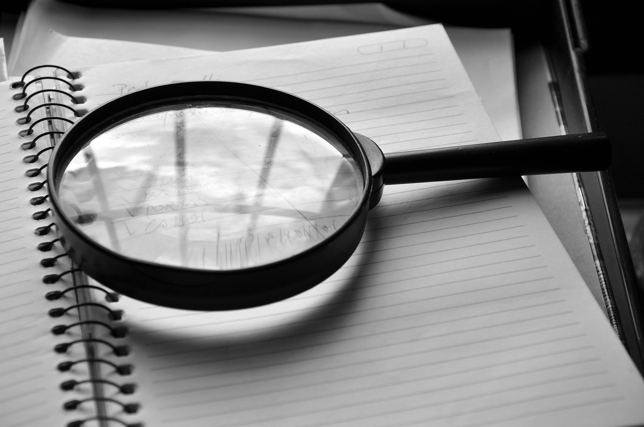 Delivery percentage in stocks: magnifying glass resting on an open notebook