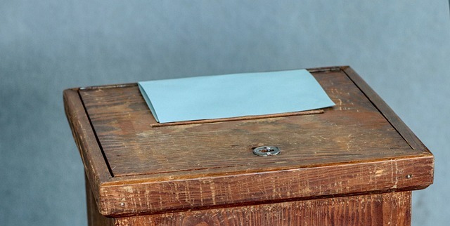 Differential voting rights shares: a wooden ballot box with a blank envelope in the slot