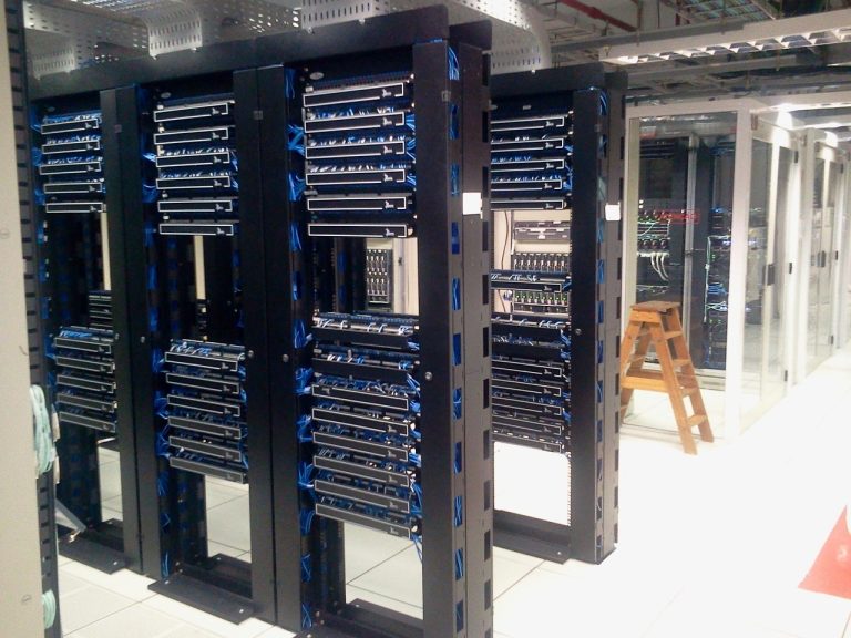E2E Networks Q2 results: rows of server racks with blue network cabling in a data centre