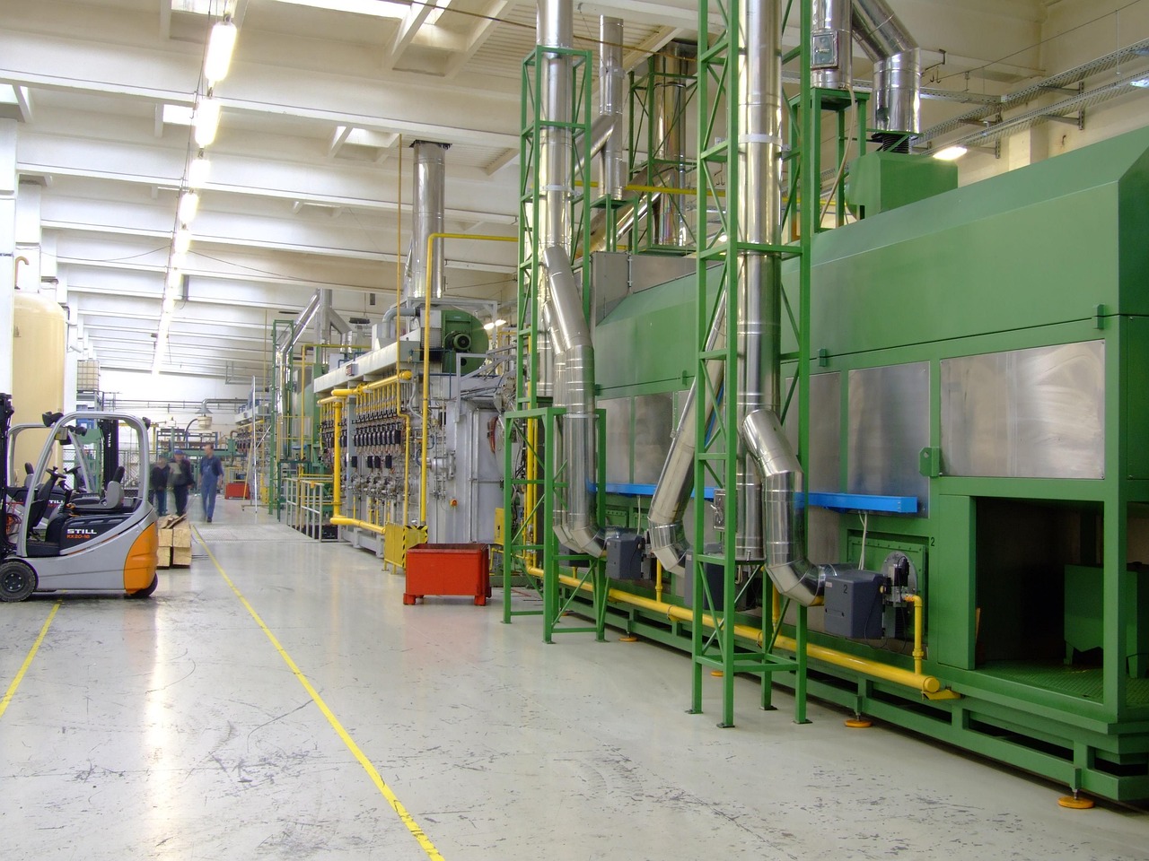 EBIT margin in results: a factory production line with green machinery, ducts and a forklift on the shop floor
