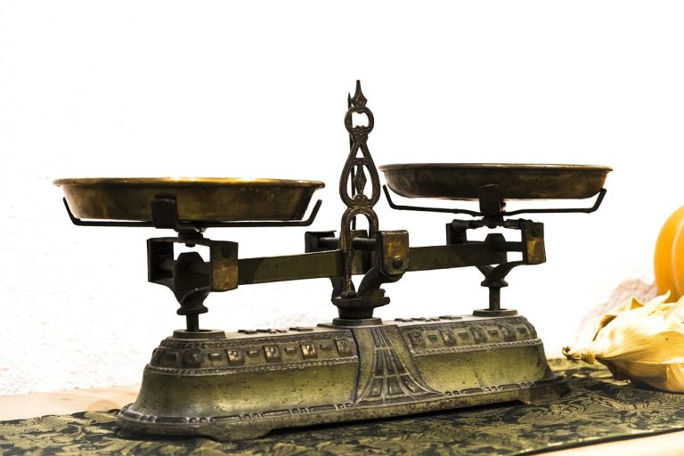 EV to sales ratio concept: an antique brass balance scale weighing two sides