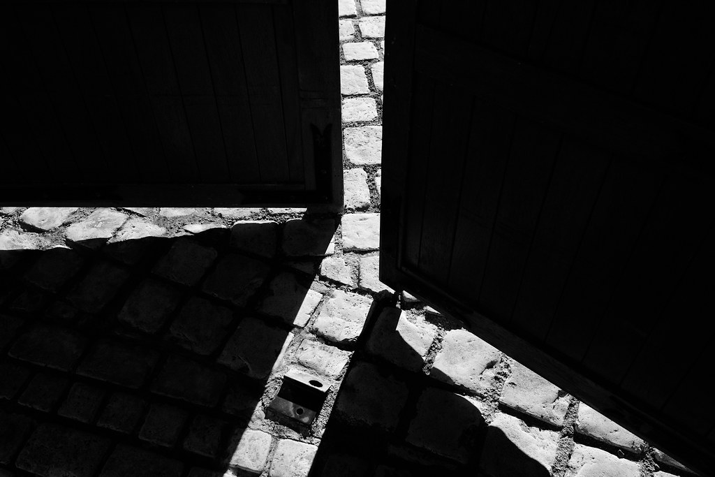 Exit load in mutual funds: a heavy wooden door swinging open onto a sunlit cobbled street