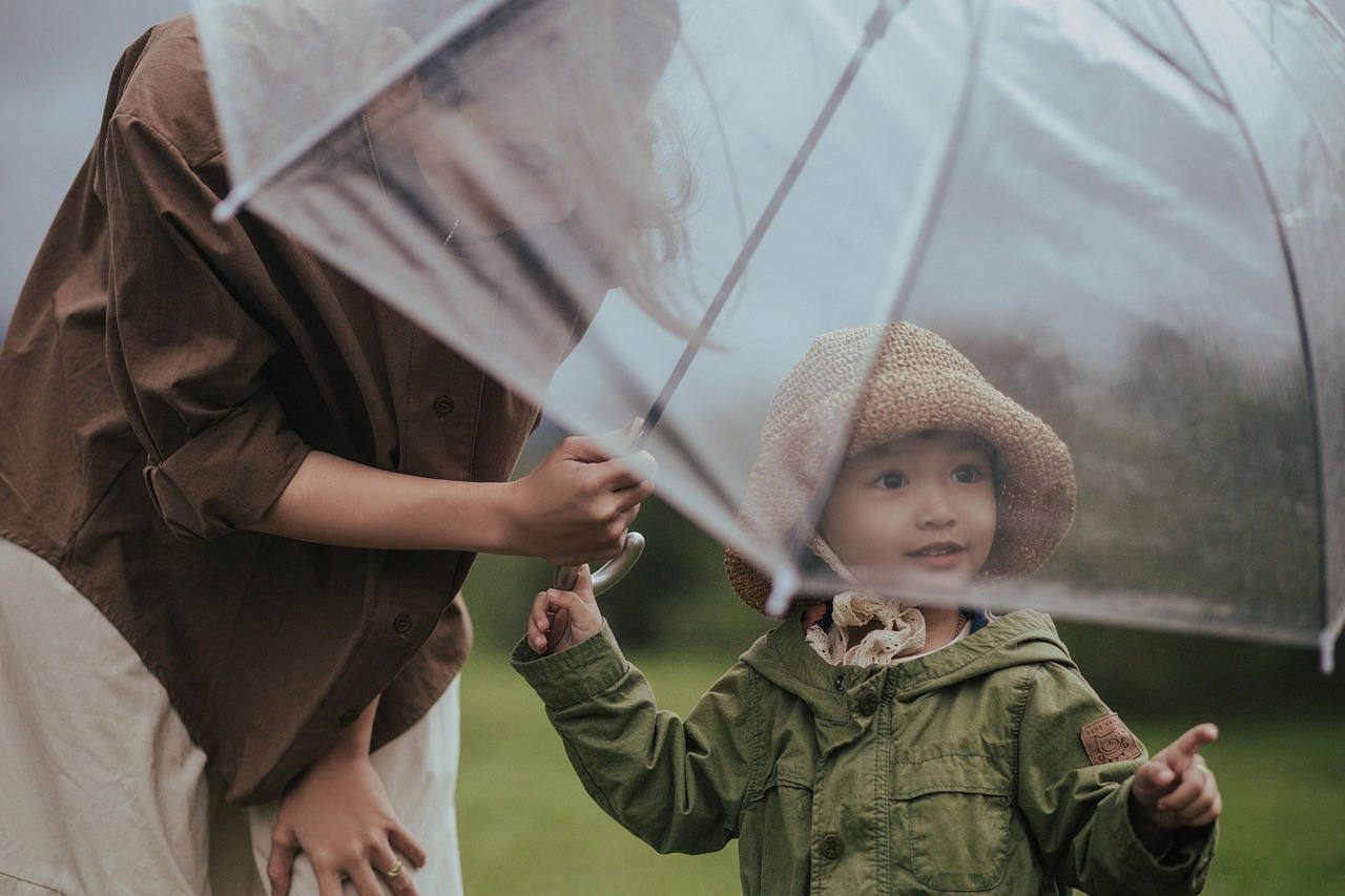 HDFC Life Q2 results: an adult holds a clear umbrella over a young child in the rain