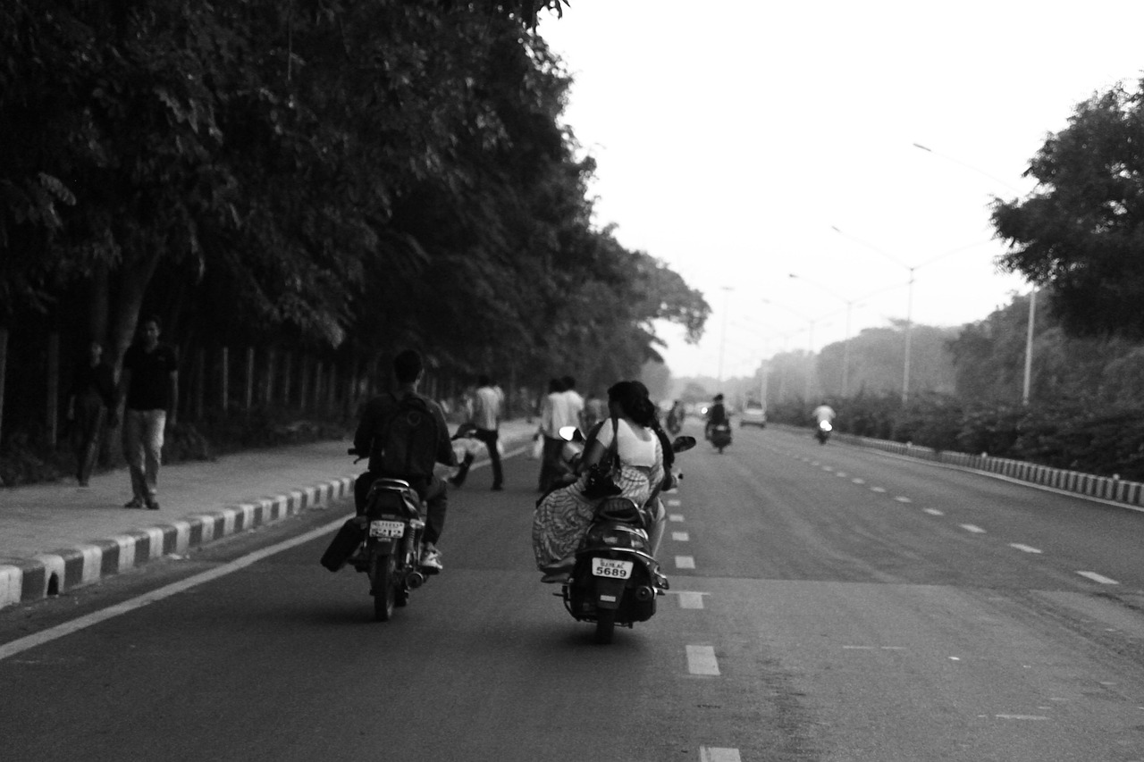 Hero MotoCorp Q2 results: motorcycles and scooters riding down a wide tree-lined Indian road