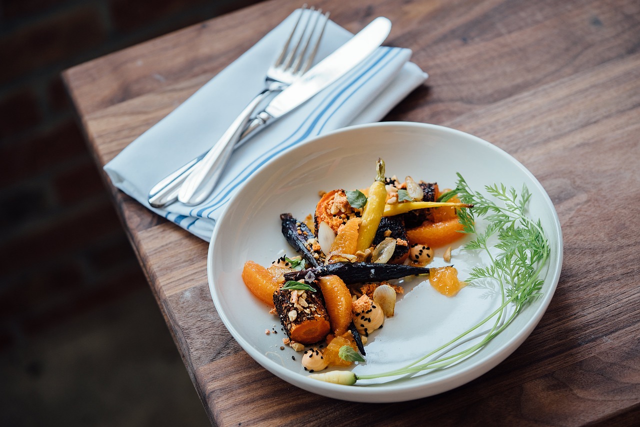 Hunger Pangs IPO: a plated vegetarian dish with cutlery on a wooden restaurant table