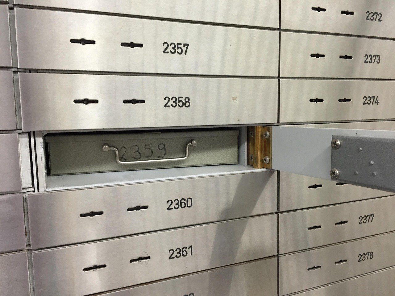 IEPF claim for unclaimed shares: a bank safe deposit locker pulled open in a wall of numbered lockers