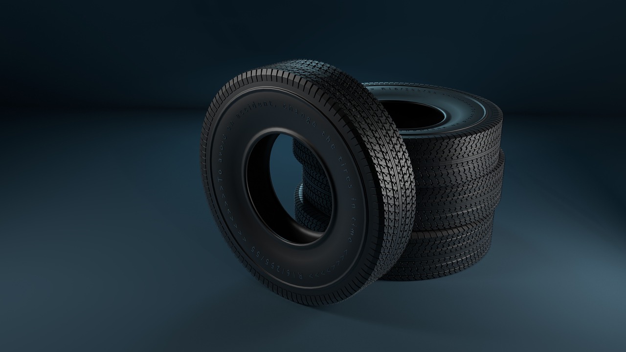 Balkrishna Industries Pirelli deal: a stack of new black car tyres on a dark studio floor