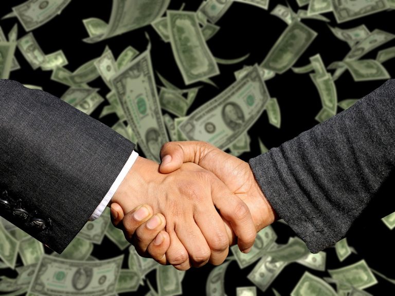 Revenue recognition under Ind AS 115: two people shaking hands on a deal with banknotes falling in the background
