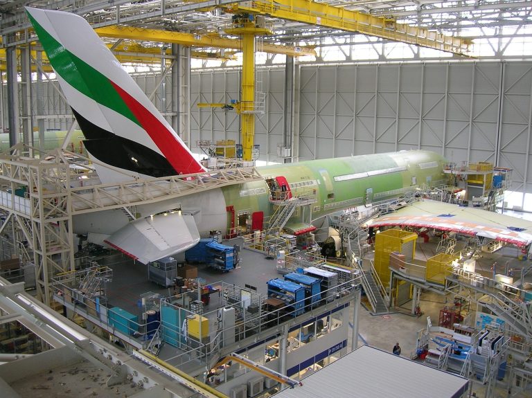 Raymond name change to aerospace and defence: wide-body aircraft fuselage and wing sections on an assembly line inside a hangar