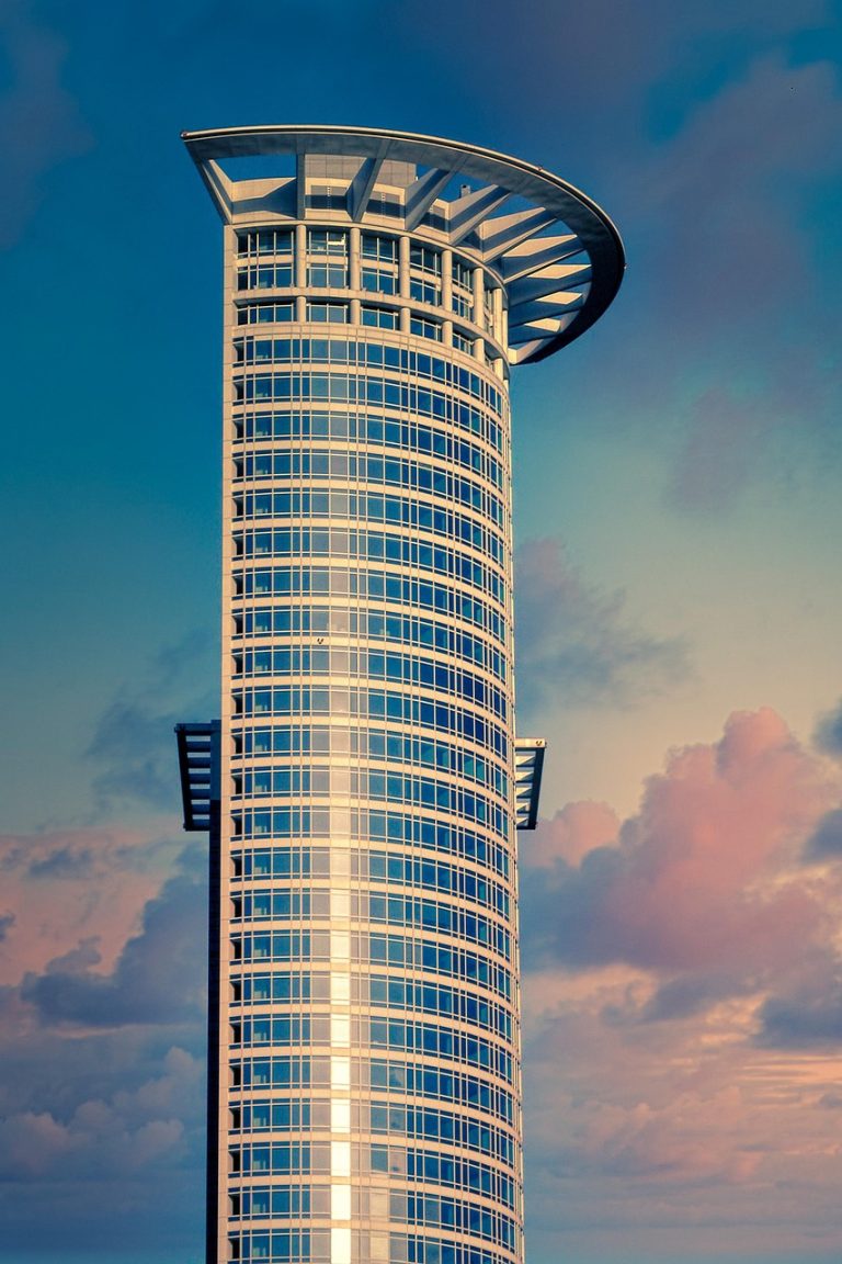 Yes Bank AT1 coupon: tall cylindrical glass office tower against an evening sky