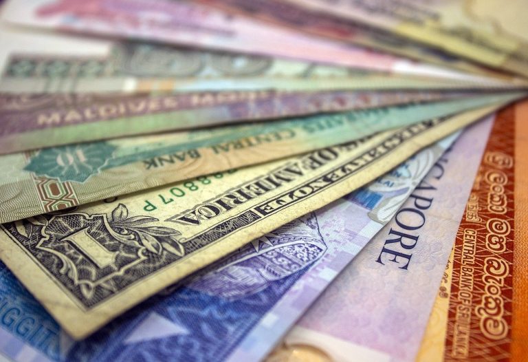 FCCB meaning concept: a fan of foreign currency banknotes from several countries, including a US dollar note