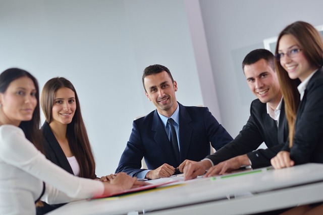 Employee stock purchase scheme: colleagues seated around an office meeting table, the kind of staff an ESPS turns into shareholders