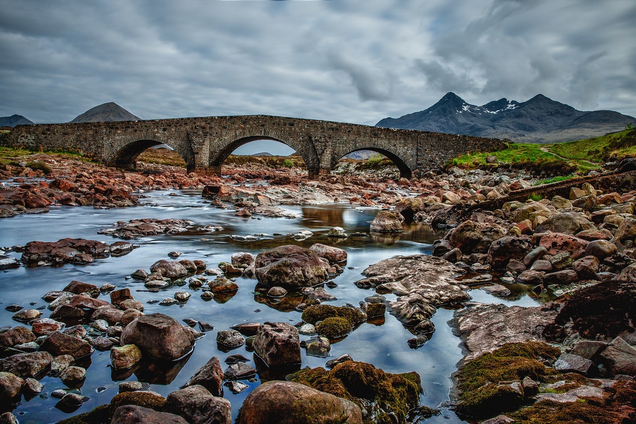 Debt service coverage ratio: an old stone arch bridge carrying its load across a rocky river, like earnings carrying debt repayments