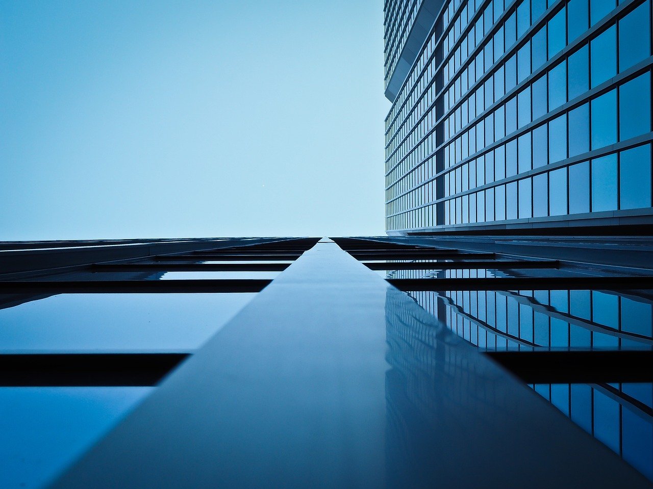QIB portion in IPO: glass office towers of large institutions seen from below against a clear sky