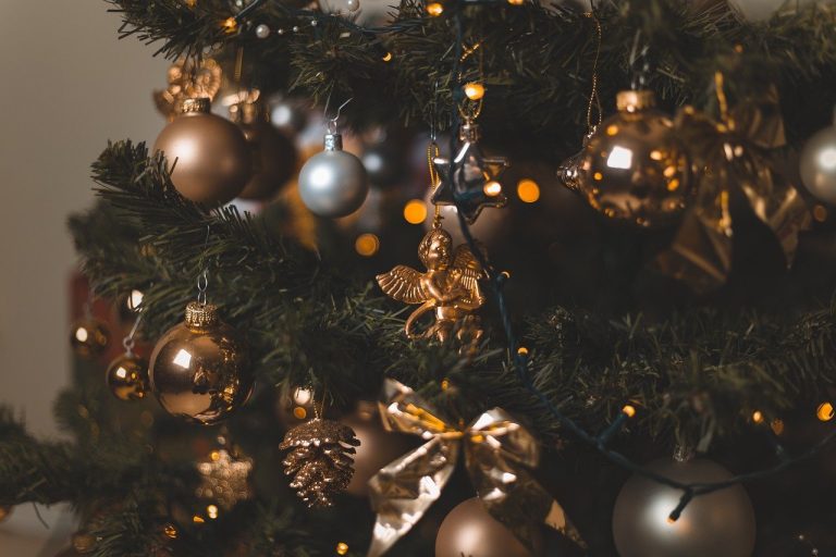 Christmas tree options spread concept: close-up of a decorated Christmas tree with gold baubles