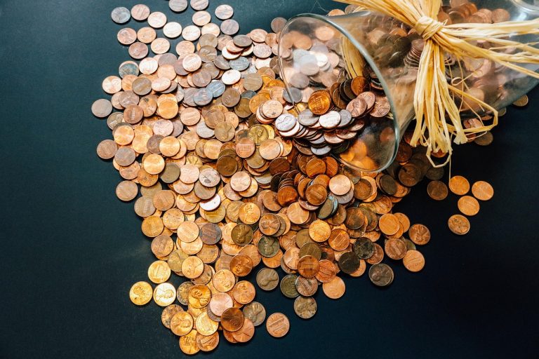 Non-institutional investor IPO: copper coins spilling out of a tipped glass jar onto a dark table