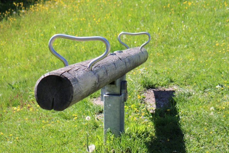 Strap and strip options strategy: a wooden playground seesaw tilted to one side on a sunny lawn