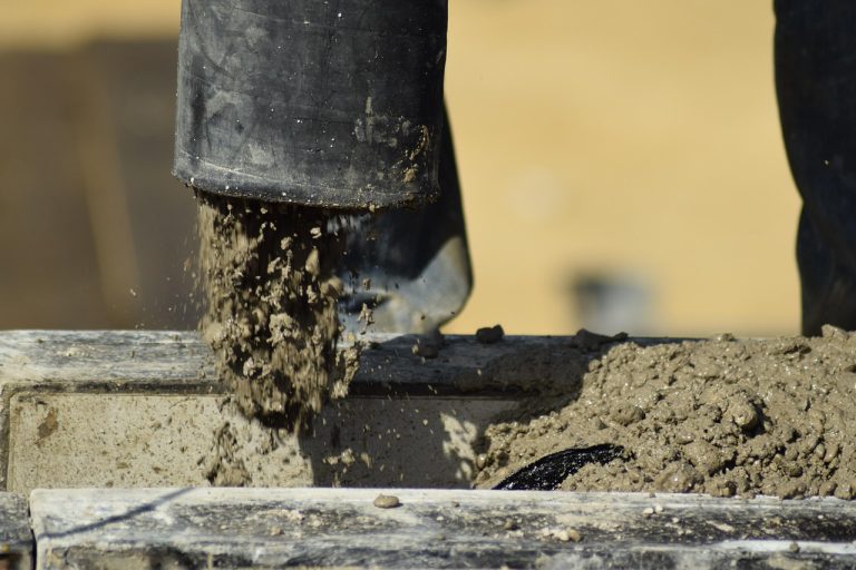 Shree Cement Q2 results: wet concrete pouring from a pump hose into formwork on a construction site