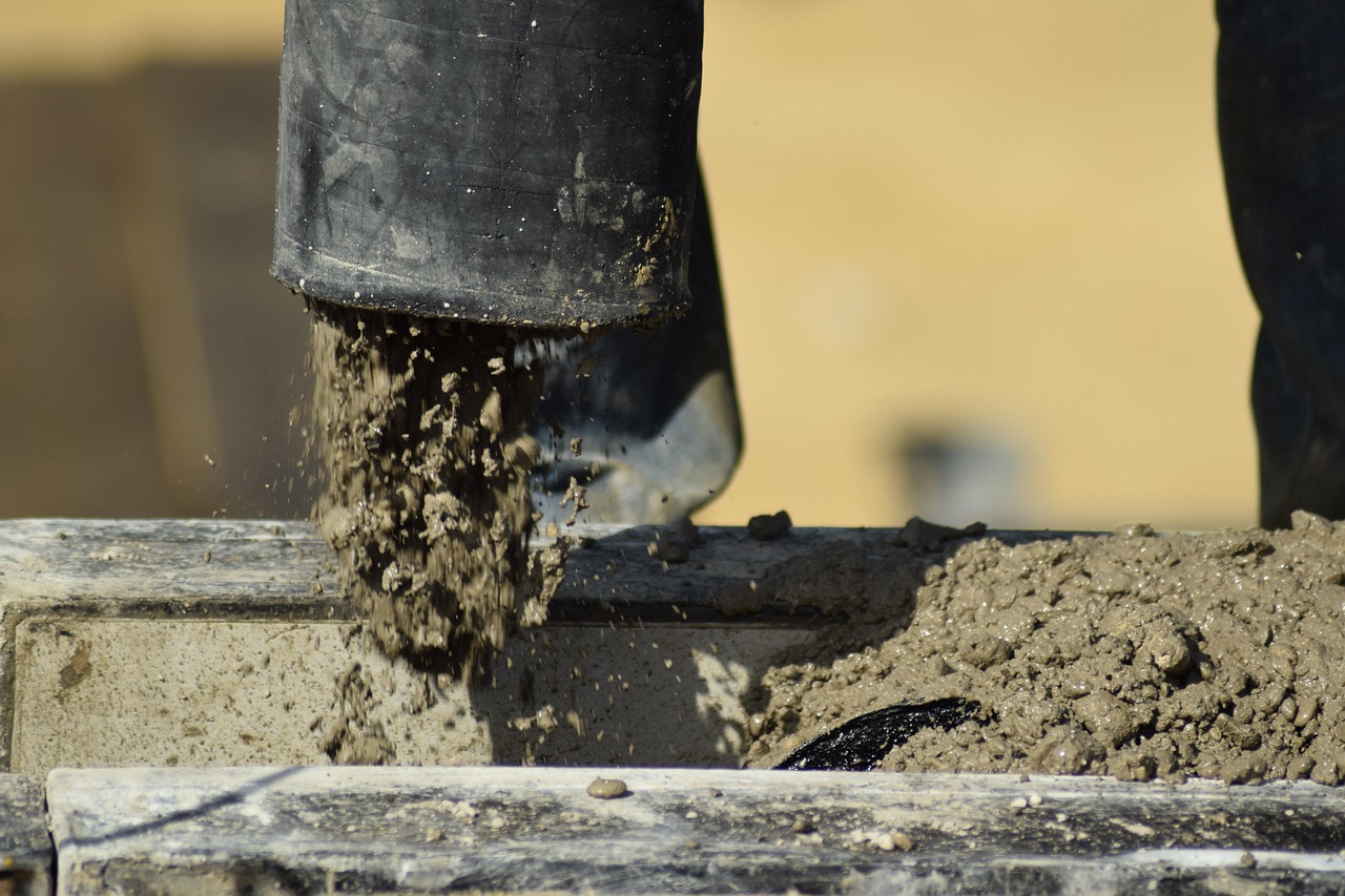 Shree Cement Q2 results: wet concrete pouring from a pump hose into formwork on a construction site