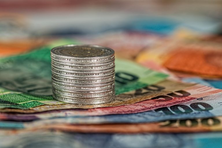IndusInd Bank Q2 results: a stack of coins resting on colourful banknotes