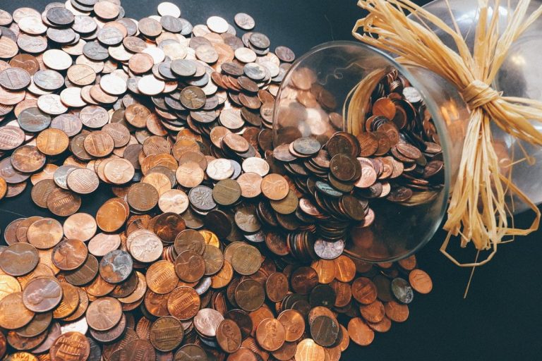 UTI AMC Q2 results: coins spilling from a glass savings jar