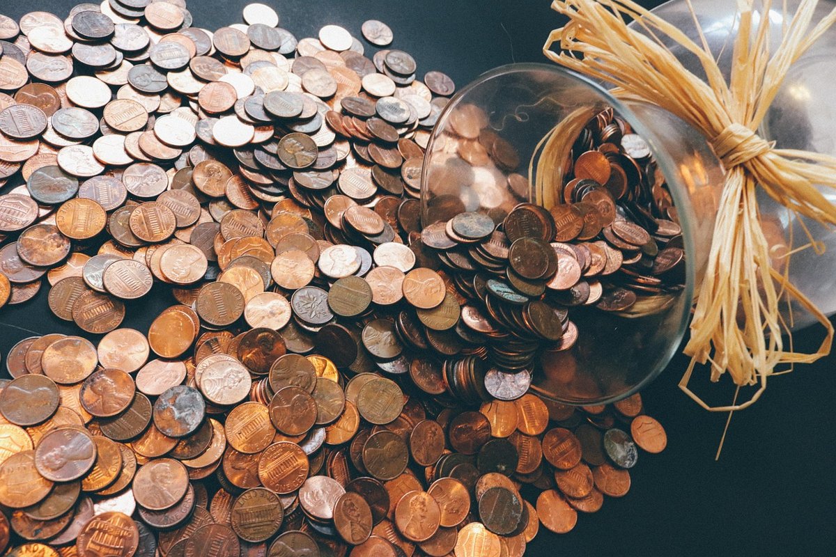 UTI AMC Q2 results: coins spilling from a glass savings jar