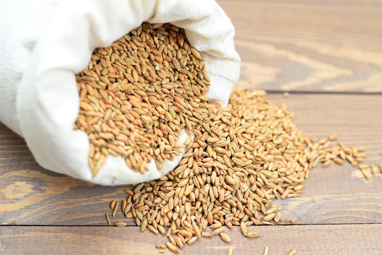 Accumulation distribution line: cereal grains spilling out of an open cloth sack onto a wooden table