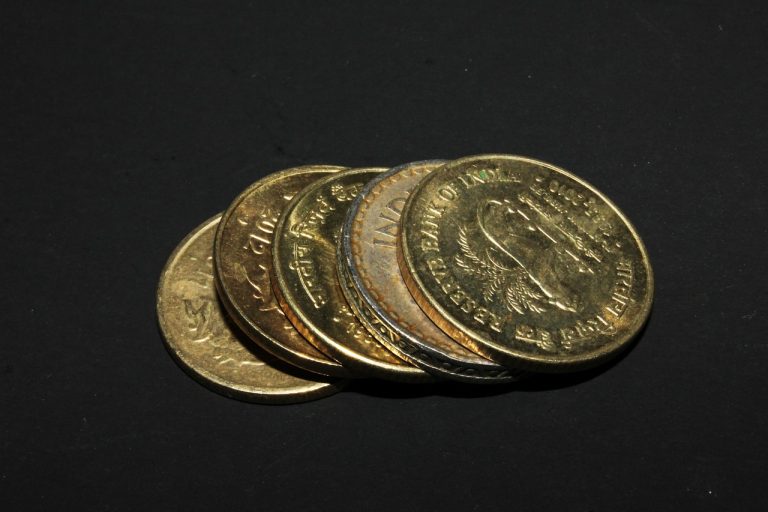 Liquid ETF: a stack of Indian rupee coins on a dark background, idle cash waiting to be parked