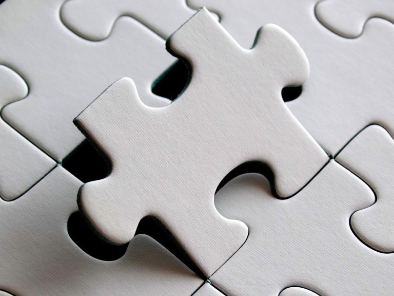 Synthetic long position: two white jigsaw puzzle pieces fitting together