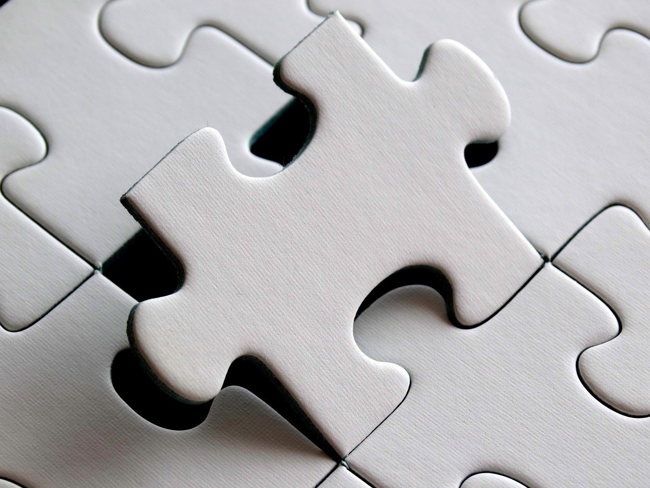 Synthetic long position: two white jigsaw puzzle pieces fitting together