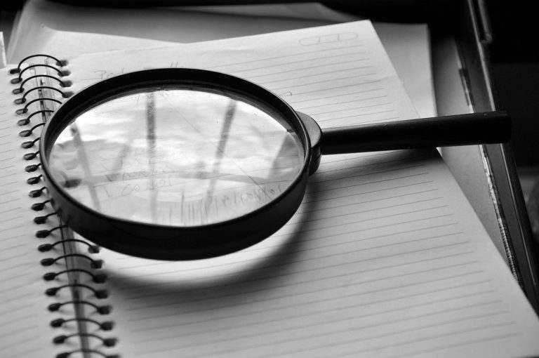 Emphasis of matter in audit report: magnifying glass resting on an open notebook